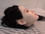 Hana hard silicone doll head with implanted black hair, side profile